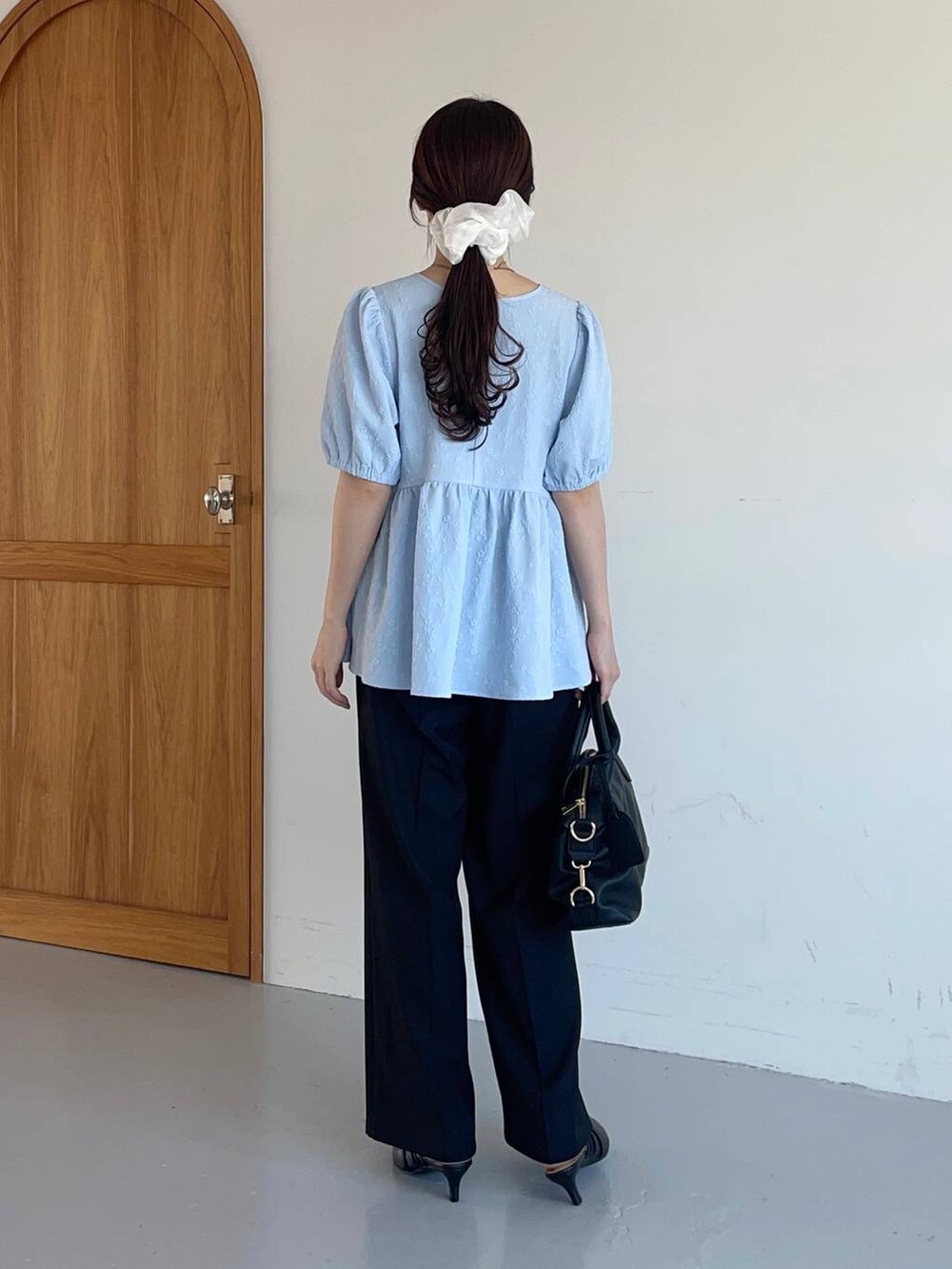 ブラック系のスラックス、ブラック系のパンプス、ブラック系のボストンバッグを着用したレディースの夏コーディネートの2枚目の写真