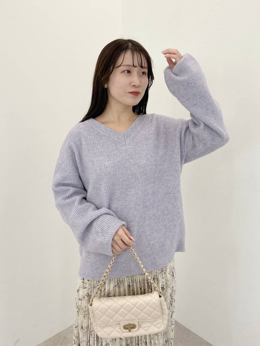 パープル系のニット/セーター、ホワイト系のショルダーバッグ、ホワイト系のスカートを着用したレディースの冬コーディネートの3枚目の写真