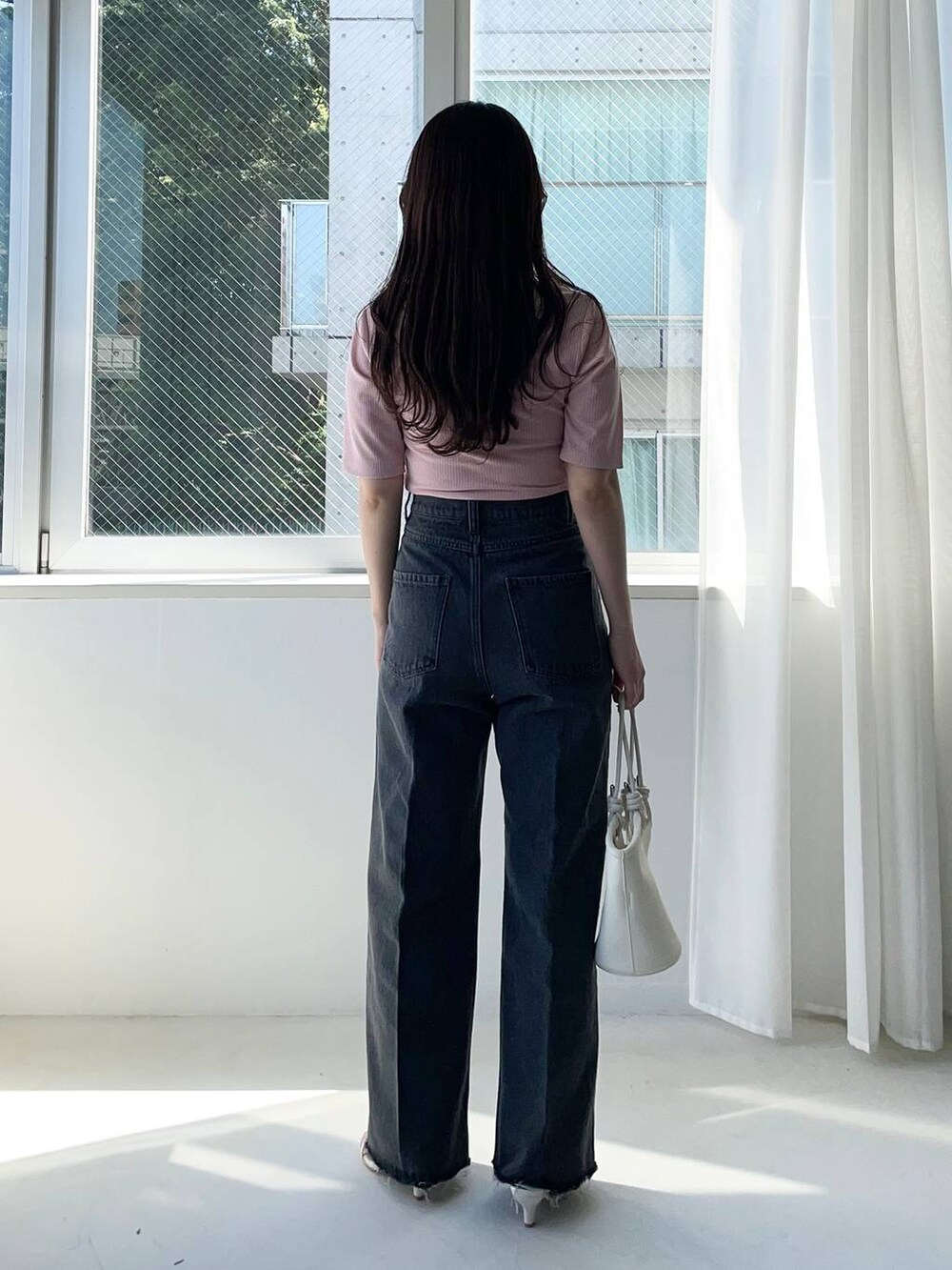 ホワイト系のハンドバッグ、ピンク系のTシャツ/カットソー、ホワイト系のサンダルを着用したレディースの夏コーディネートの2枚目の写真