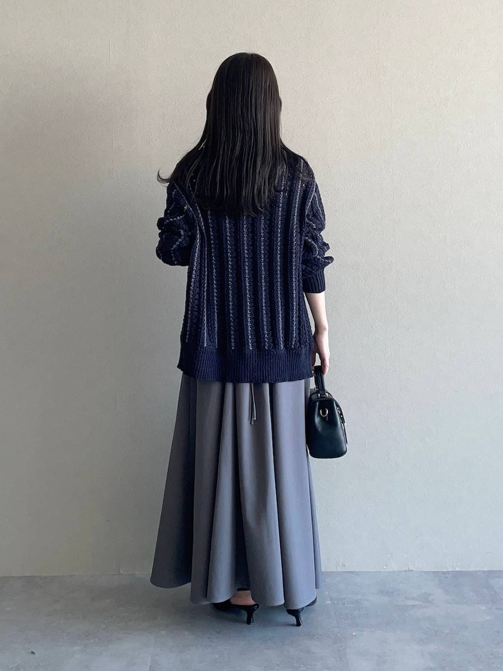 グレー系のワンピース、ブラック系のサンダル、ブルー系のカーディガン/ボレロを着用したレディースの春コーディネートの2枚目の写真