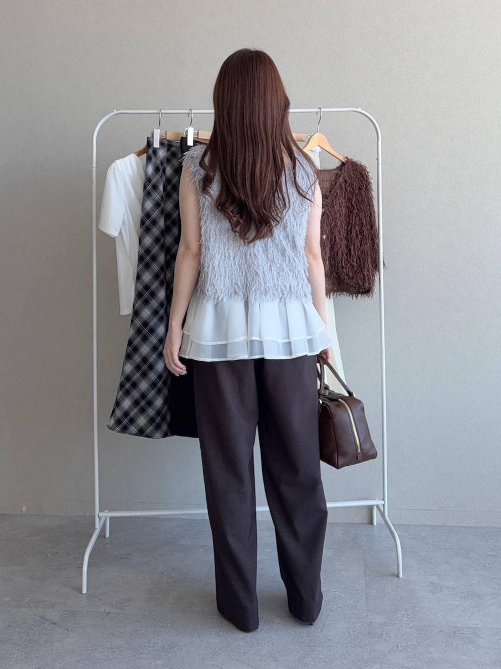 ブルー系のニット/セーター、グレー系のベスト、ブラウン系のその他パンツを着用したレディースの夏コーディネートの2枚目の写真