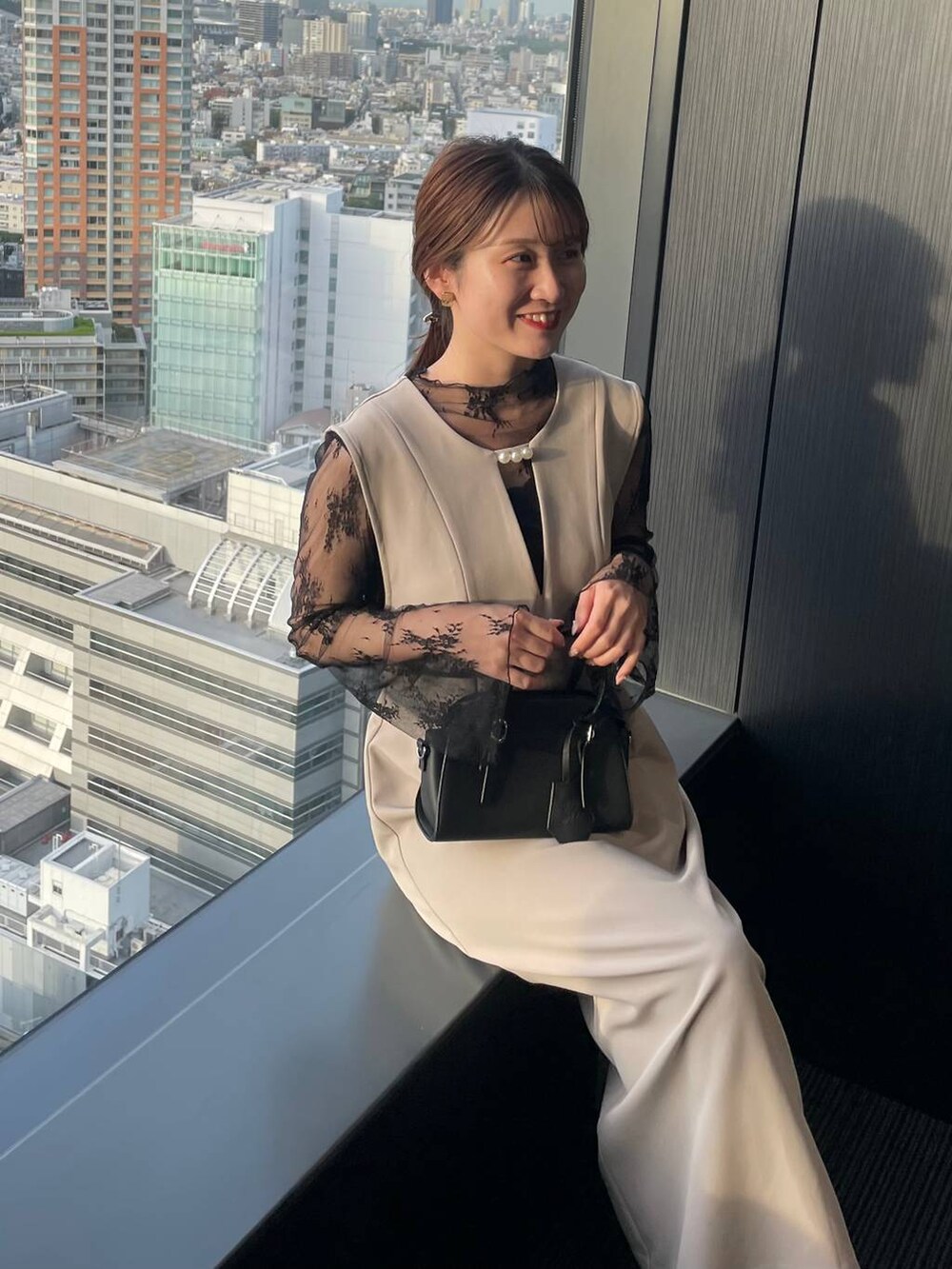 ブラック系のボストンバッグ、グレー系のドレス、ブラック系のパンプスを着用したレディースの秋コーディネートの3枚目の写真