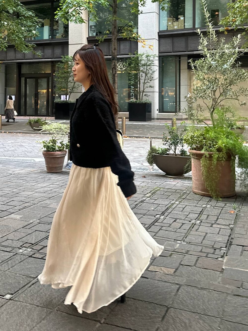 ブラック系のカーディガン/ボレロ、ホワイト系のスカートを着用したレディースの秋コーディネートの4枚目の写真