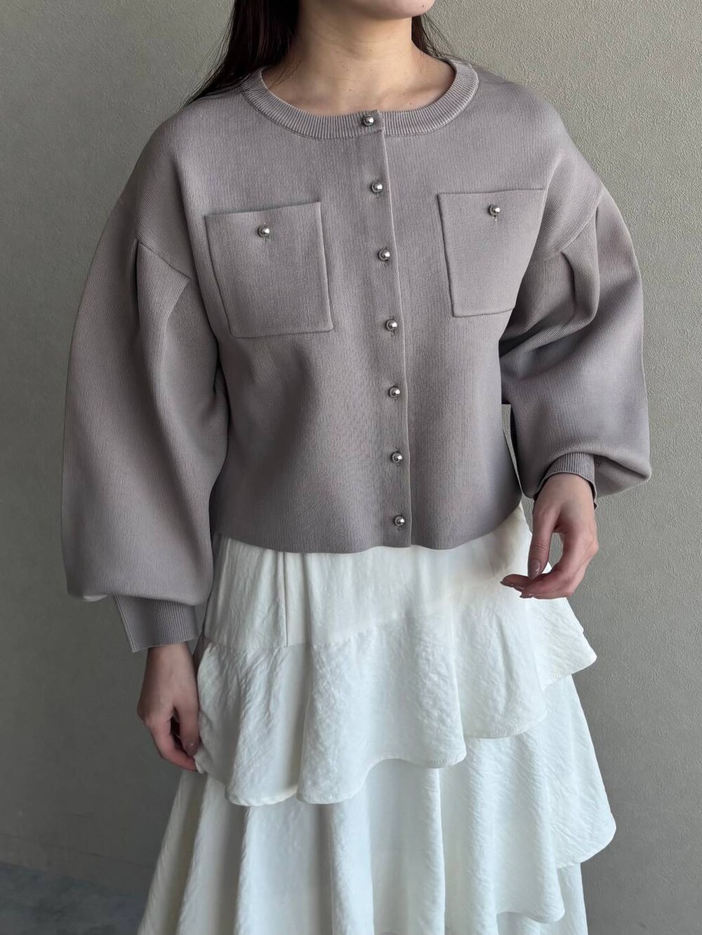 ホワイト系のブーツ、ホワイト系のショルダーバッグ、ベージュ系のカーディガン/ボレロを着用したレディースの春コーディネートの3枚目の写真