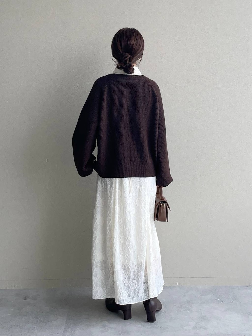 ブラウン系のニット/セーター、ホワイト系のワンピース、ブラウン系のブーツを着用したレディースの秋コーディネートの2枚目の写真