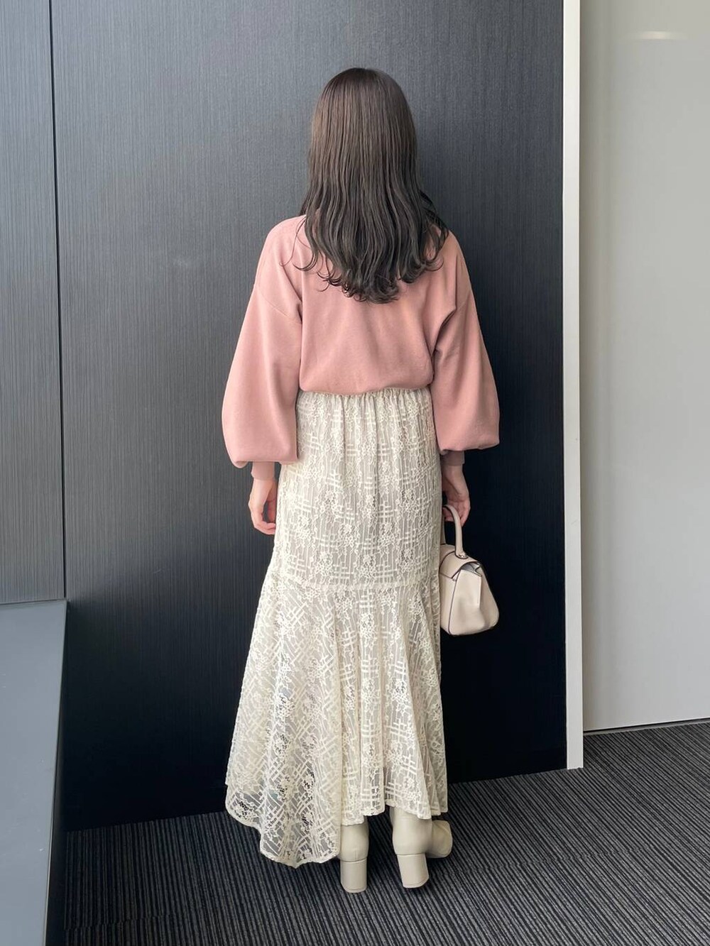 ホワイト系のハンドバッグ、ホワイト系のブーツ、ホワイト系のスカートを着用したレディースの秋コーディネートの2枚目の写真