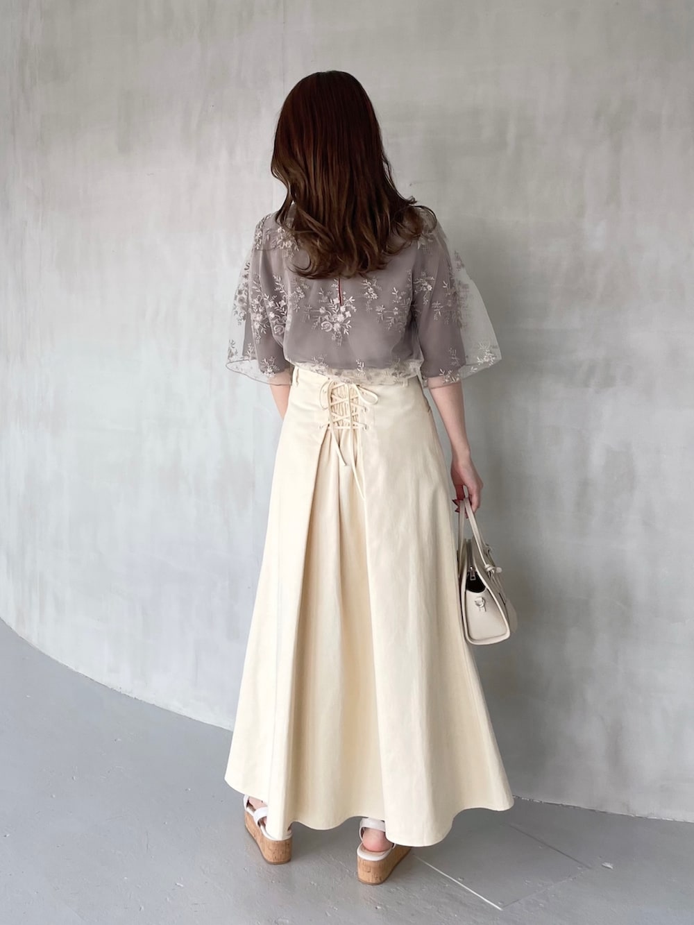 ベージュ系のシャツ/ブラウス、ホワイト系のタンクトップ、グリーン系のスカートを着用したレディースの春コーディネートの2枚目の写真