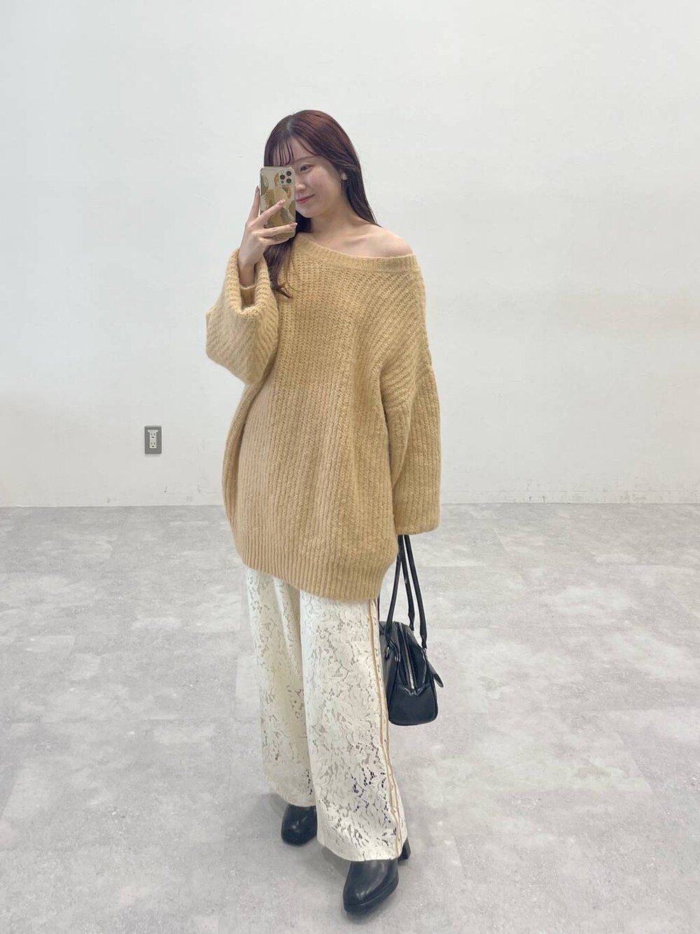 ブラック系のブーツ、ホワイト系のその他パンツ、ブラック系のハンドバッグを着用したレディースの秋コーディネートの3枚目の写真