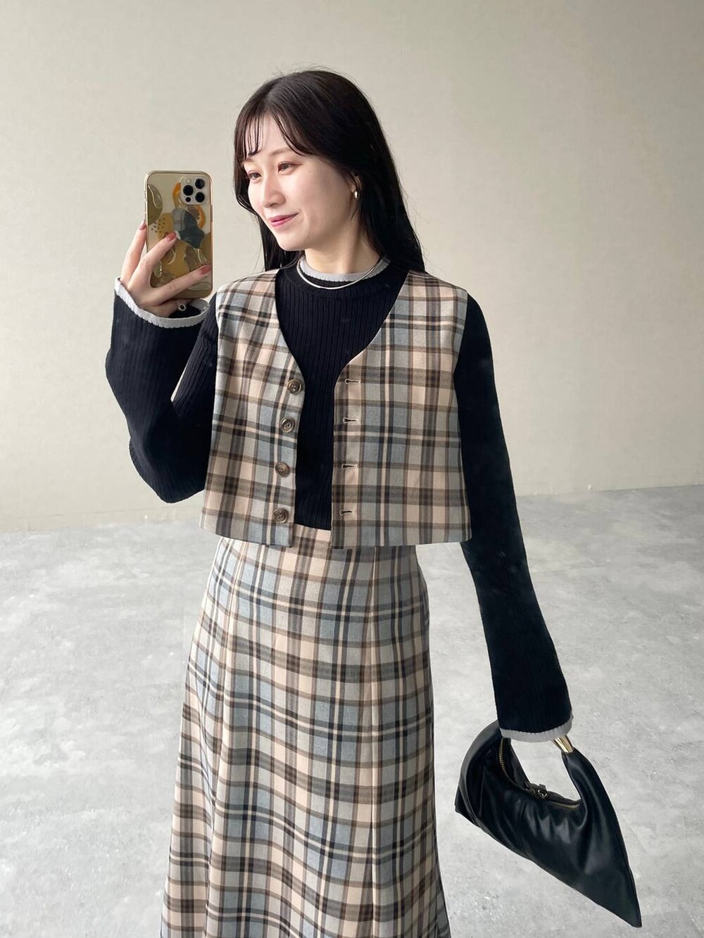 ブラック系のブルゾン、ブラック系のハンドバッグ、ブラック系のブーツを着用したレディースの秋コーディネートの5枚目の写真