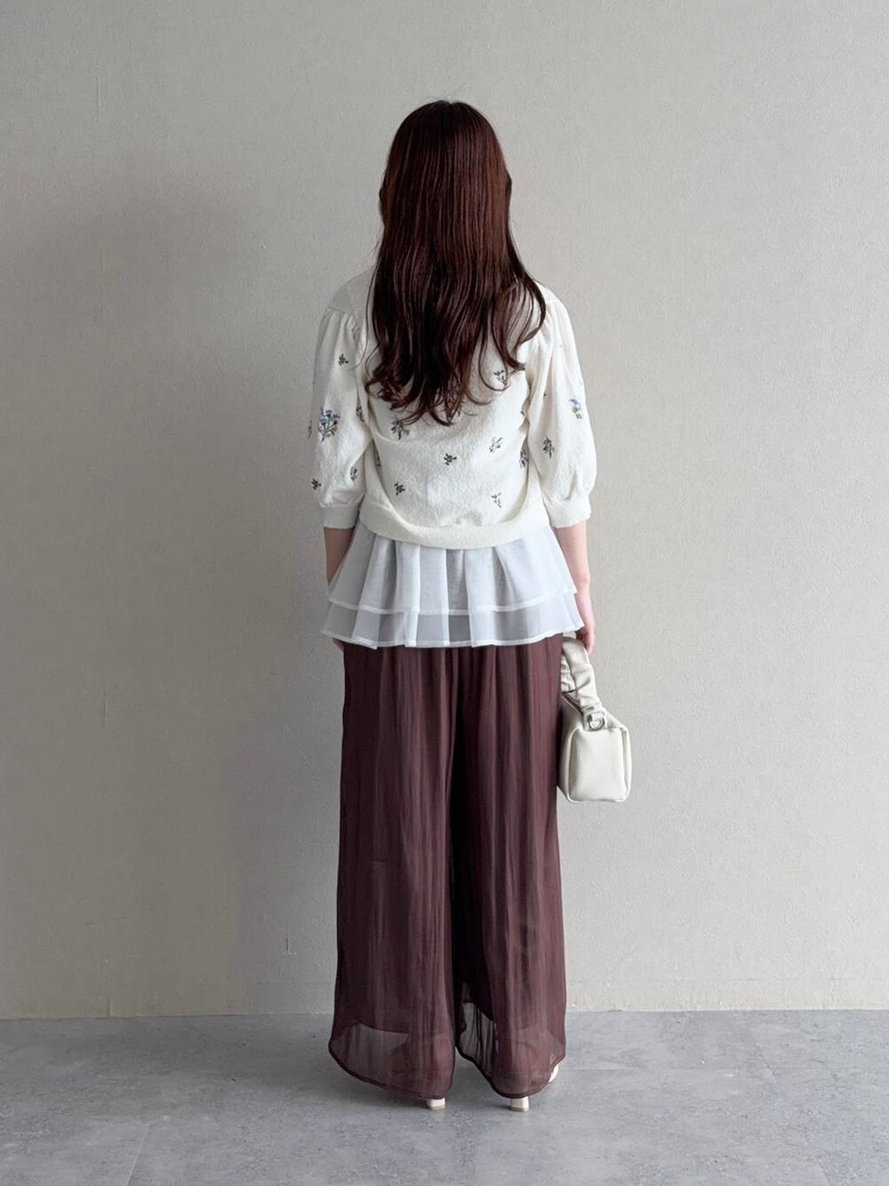 ブルー系のニット/セーター、ブラウン系のその他パンツ、ホワイト系のカーディガン/ボレロを着用したレディースの夏コーディネートの3枚目の写真