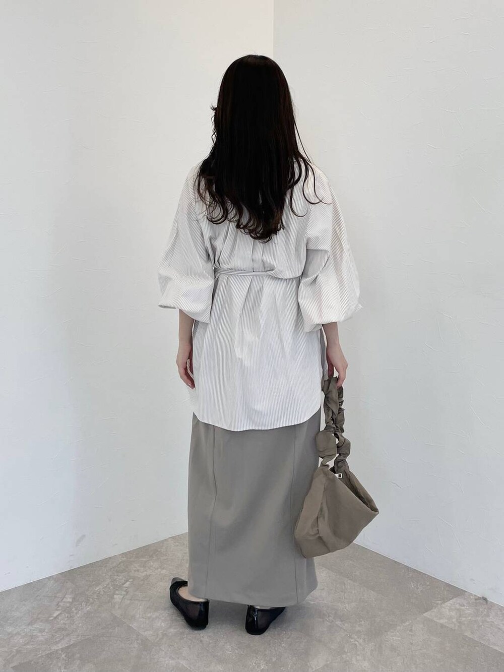 ブラック系のバレエシューズ、ベージュ系のシャツ/ブラウス、ブラウン系のショルダーバッグを着用したレディースの春コーディネートの2枚目の写真