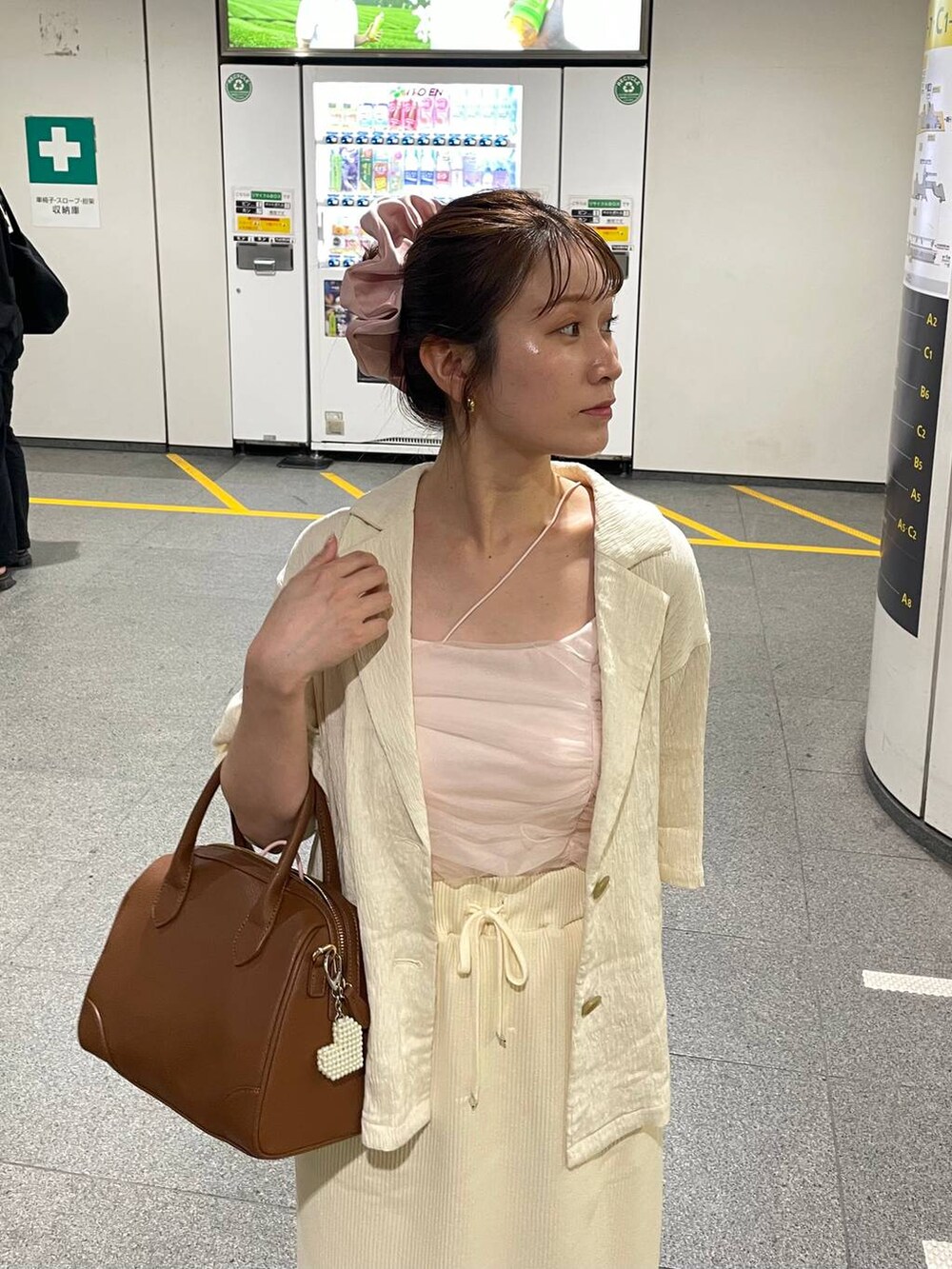 ホワイト系のスカート、ホワイト系のテーラードジャケット、ブラウン系のショルダーバッグを着用したレディースの夏コーディネートの5枚目の写真