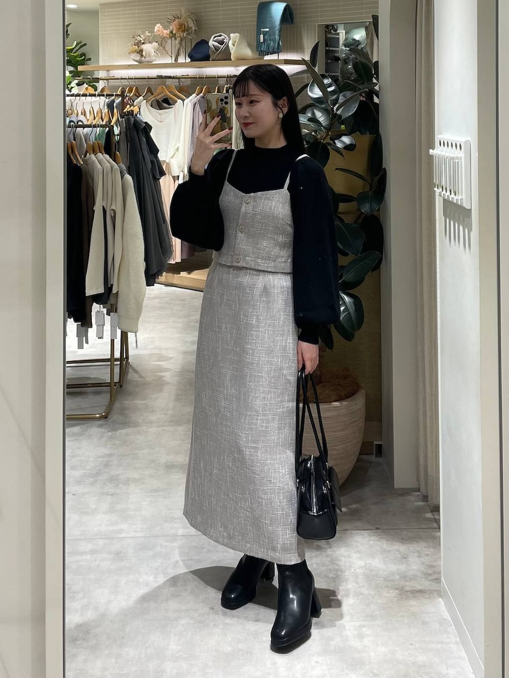 ブラック系のブーツ、ブラック系のハンドバッグ、ブラック系のニット/セーターを着用したレディースの冬コーディネートの3枚目の写真