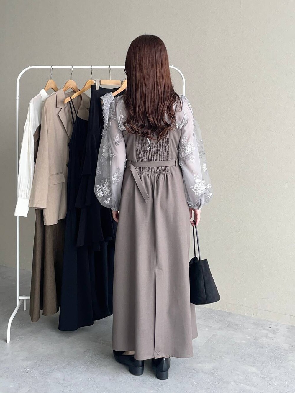 グレー系のシャツ/ブラウス、ベージュ系のワンピース、ブラック系のローファーを着用したレディースの秋コーディネートの2枚目の写真