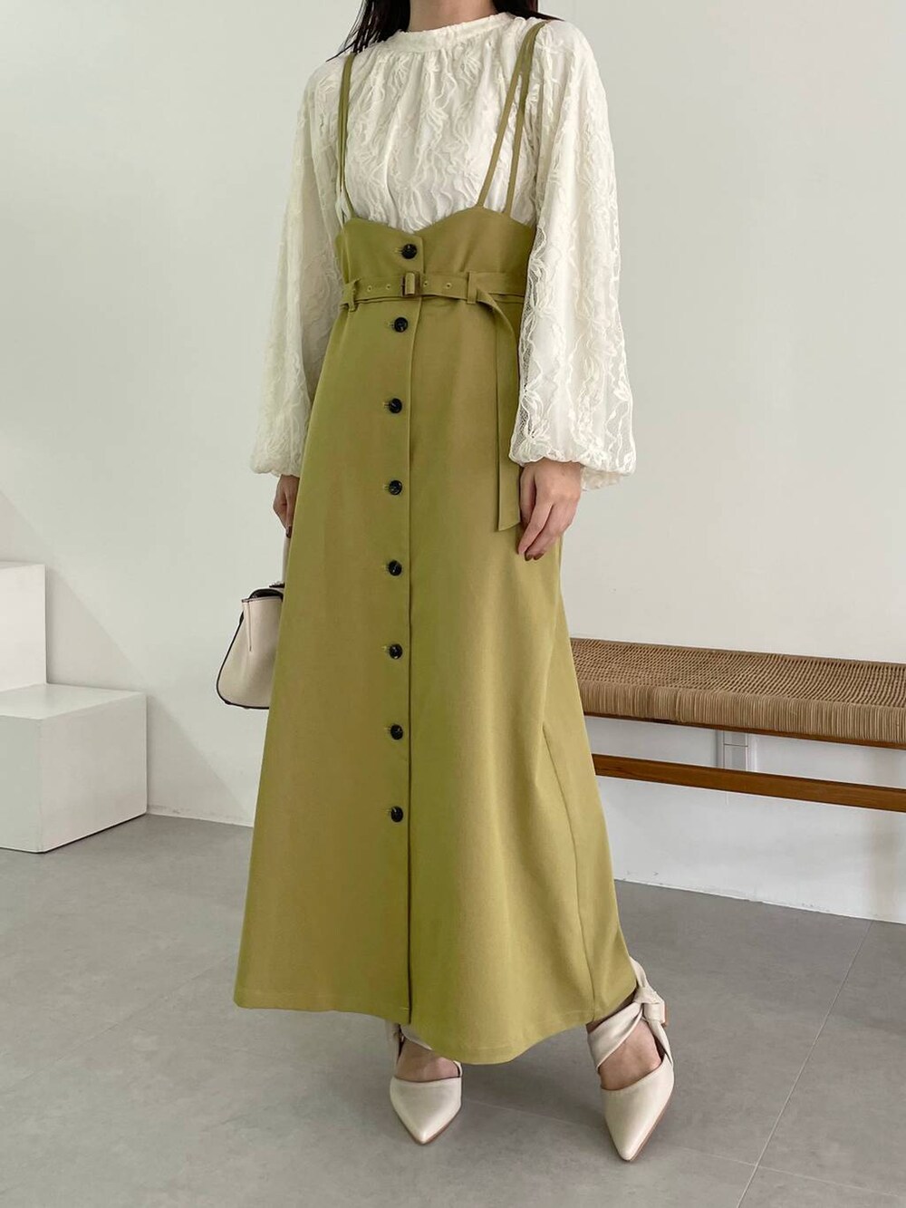 ホワイト系のハンドバッグ、イエロー系のスカート、ホワイト系のパンプスを着用したレディースの秋コーディネートの4枚目の写真