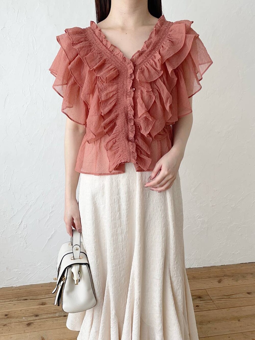 ホワイト系のスカート、ピンク系のシャツ/ブラウス、ゴールド系のパンプスを着用したレディースの春コーディネートの3枚目の写真