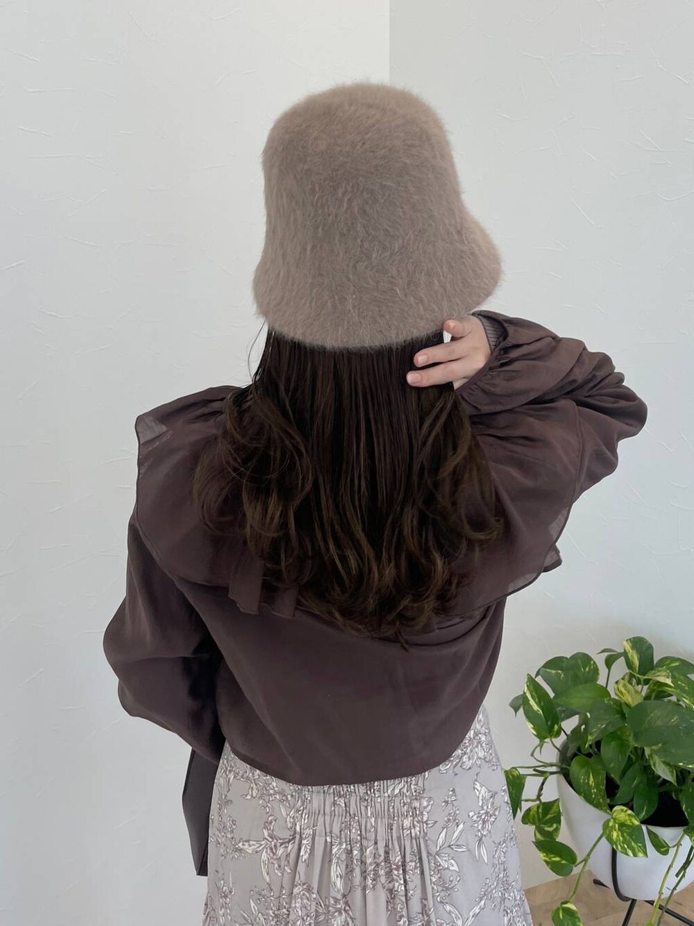 ブラウン系のハンドバッグ、ホワイト系のブーツ、ブラウン系のシャツ/ブラウスを着用したレディースの冬コーディネートの5枚目の写真