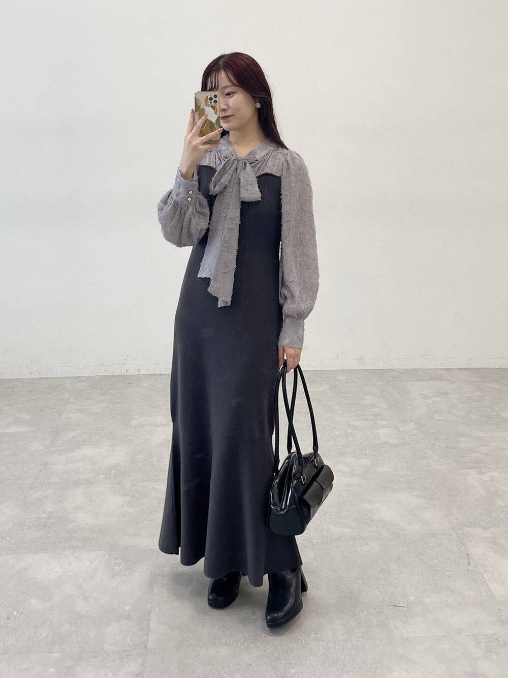 ホワイト系のブルゾン、ブラック系のブーツ、グレー系のワンピースを着用したレディースの秋コーディネートの9枚目の写真