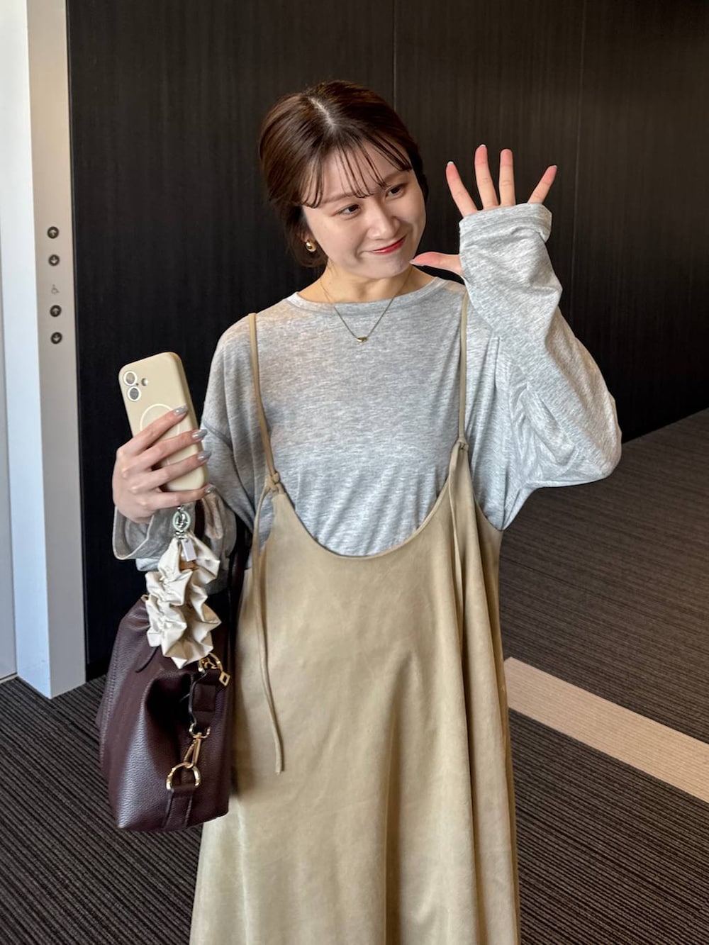 グレー系のTシャツ/カットソー、ブラウン系のボストンバッグ、ベージュ系のワンピースを着用したレディースの冬コーディネートの3枚目の写真