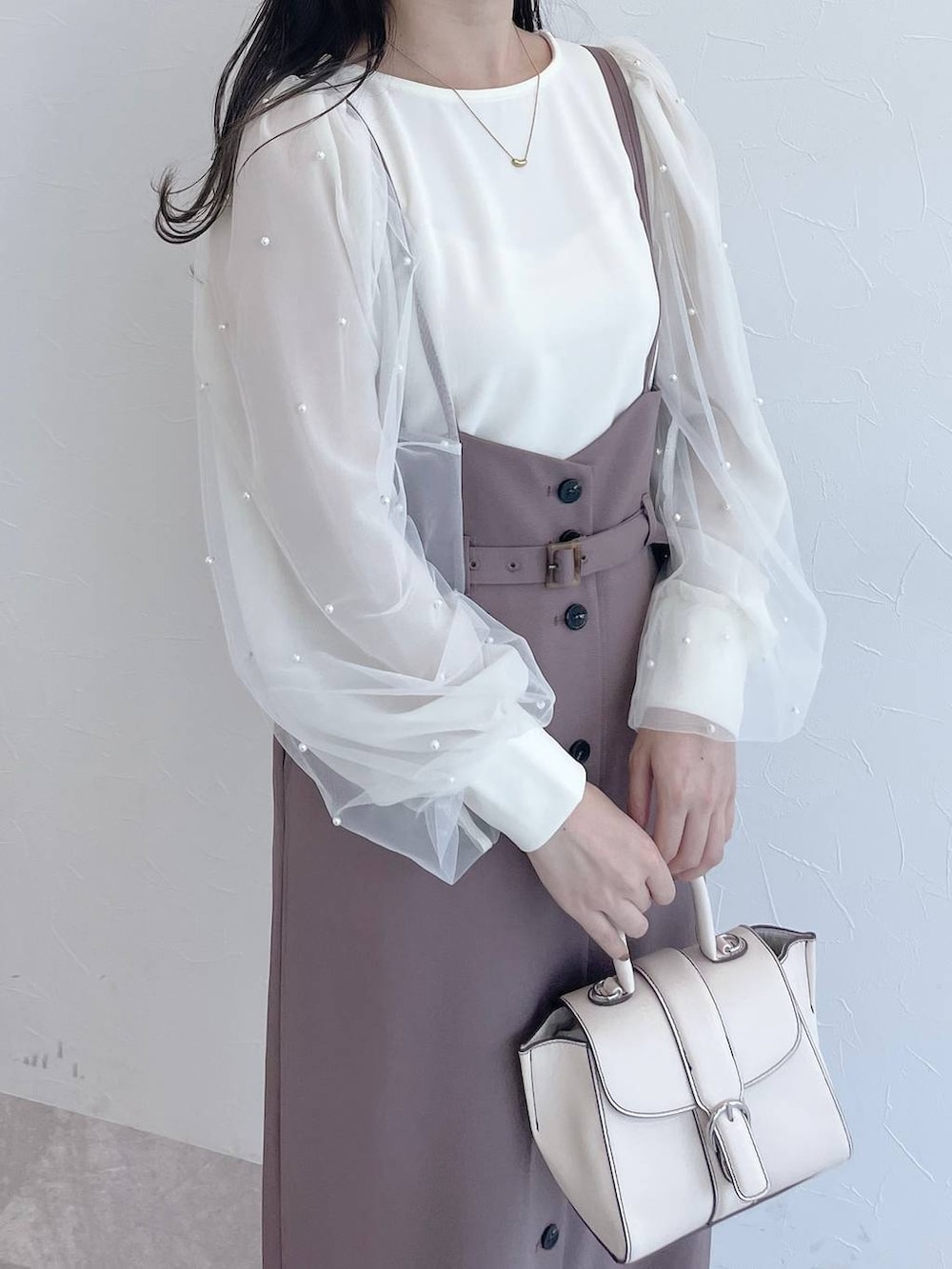 ホワイト系のハンドバッグ、ホワイト系のブーツ、ホワイト系のTシャツ/カットソーを着用したレディースの夏コーディネートの3枚目の写真