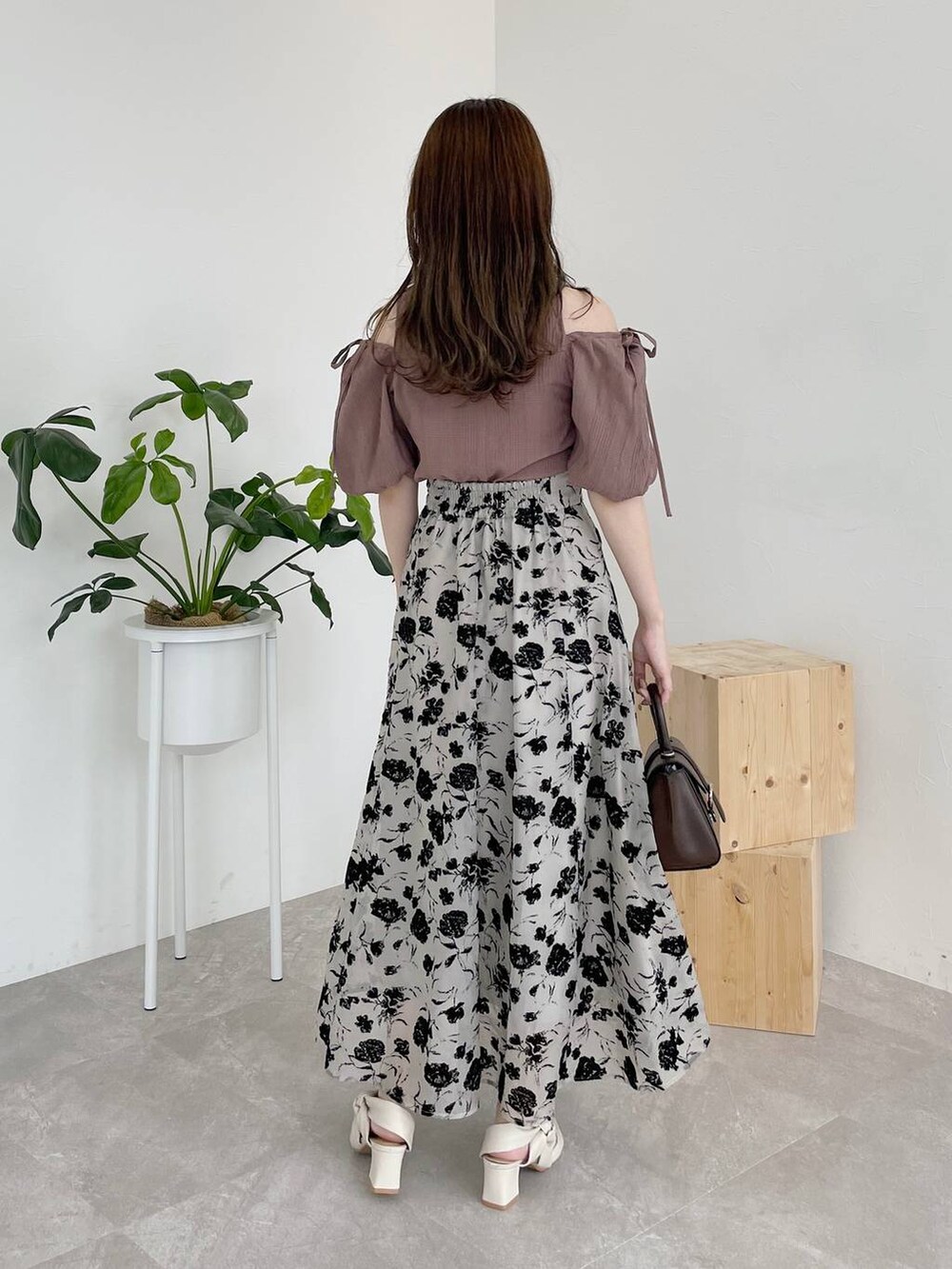 ブラウン系のシャツ/ブラウス、ブラウン系のハンドバッグ、ベージュ系のスカートを着用したレディースの夏コーディネートの2枚目の写真