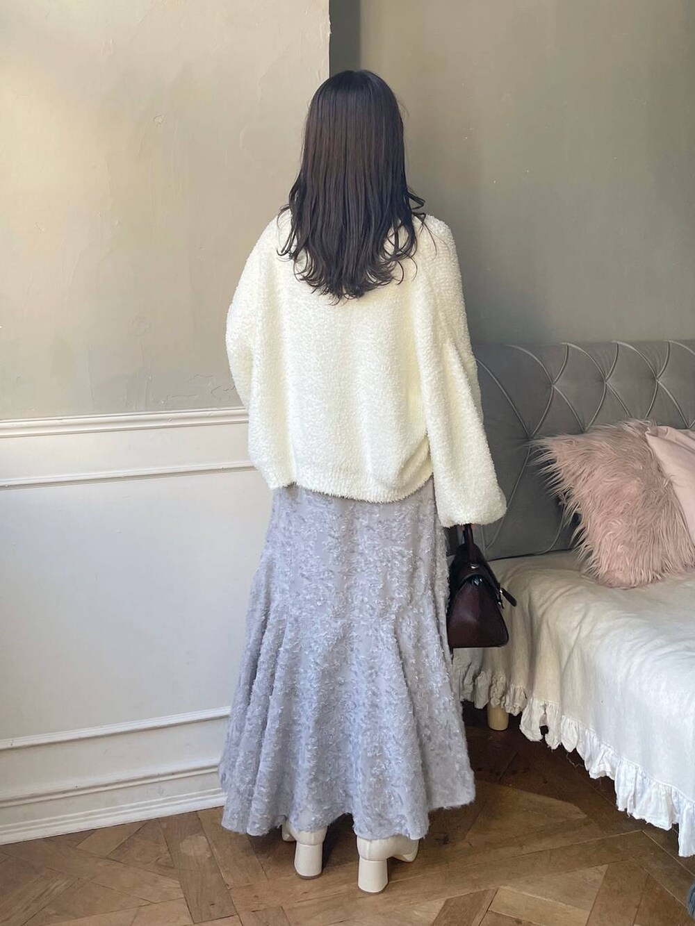 ブラウン系のハンドバッグ、ホワイト系のブーツ、ホワイト系のTシャツ/カットソーを着用したレディースの秋コーディネートの2枚目の写真