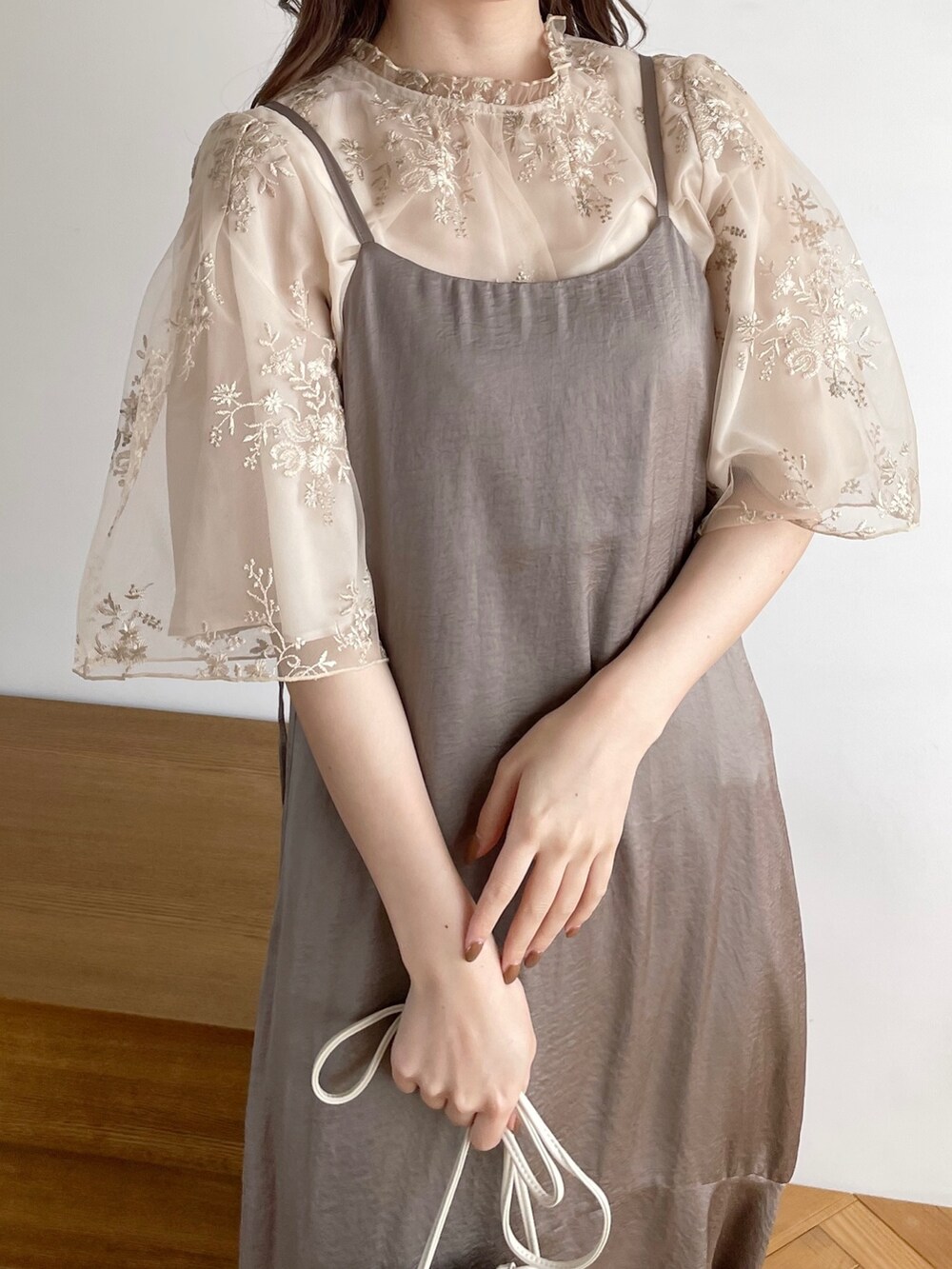 ホワイト系のシャツ/ブラウス、ベージュ系のワンピース、ホワイト系のショルダーバッグを着用したレディースの春コーディネートの4枚目の写真