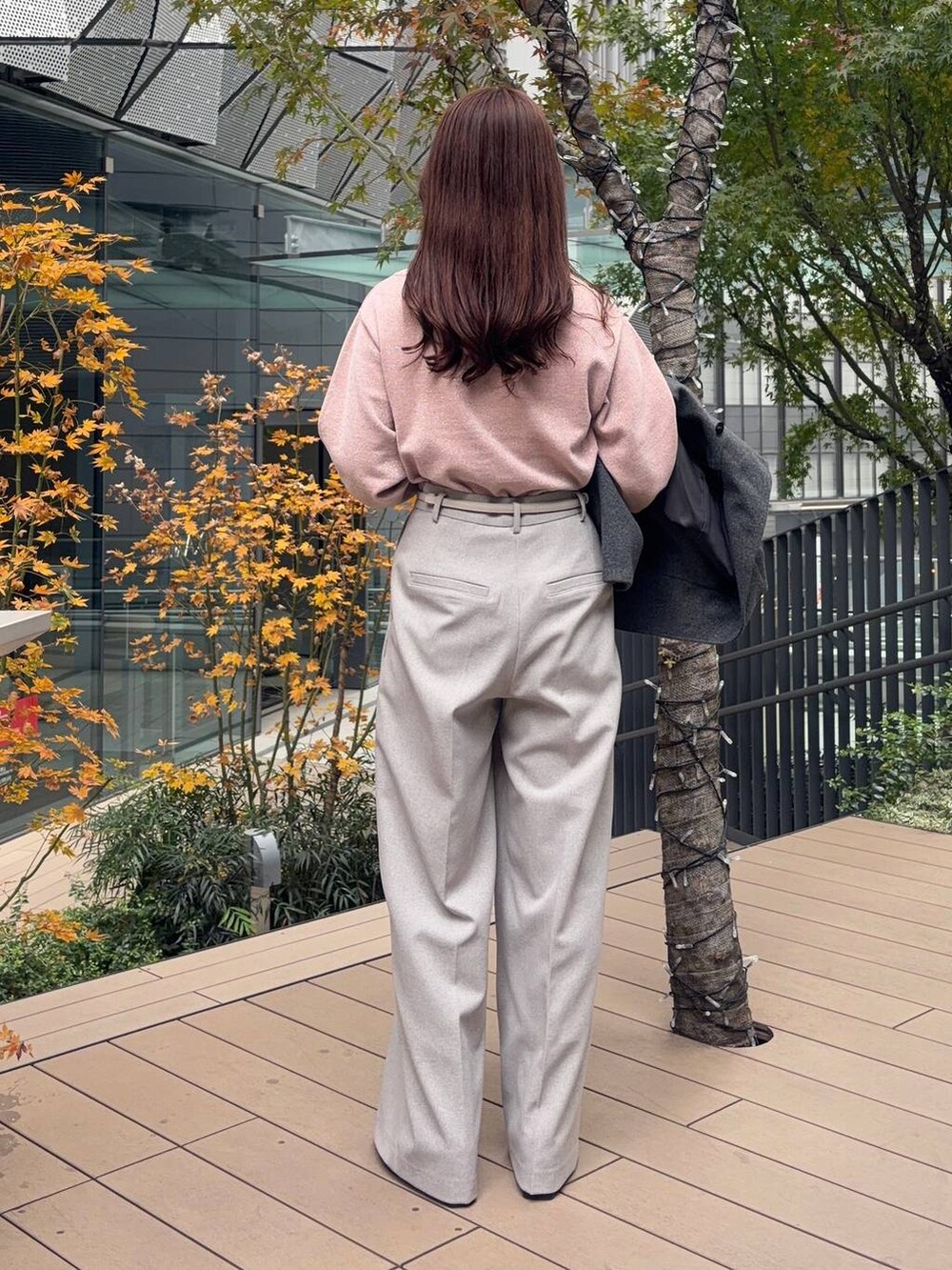 グレー系のピーコート、ピンク系のニット/セーター、ブラック系のボストンバッグを着用したレディースの冬コーディネートの4枚目の写真