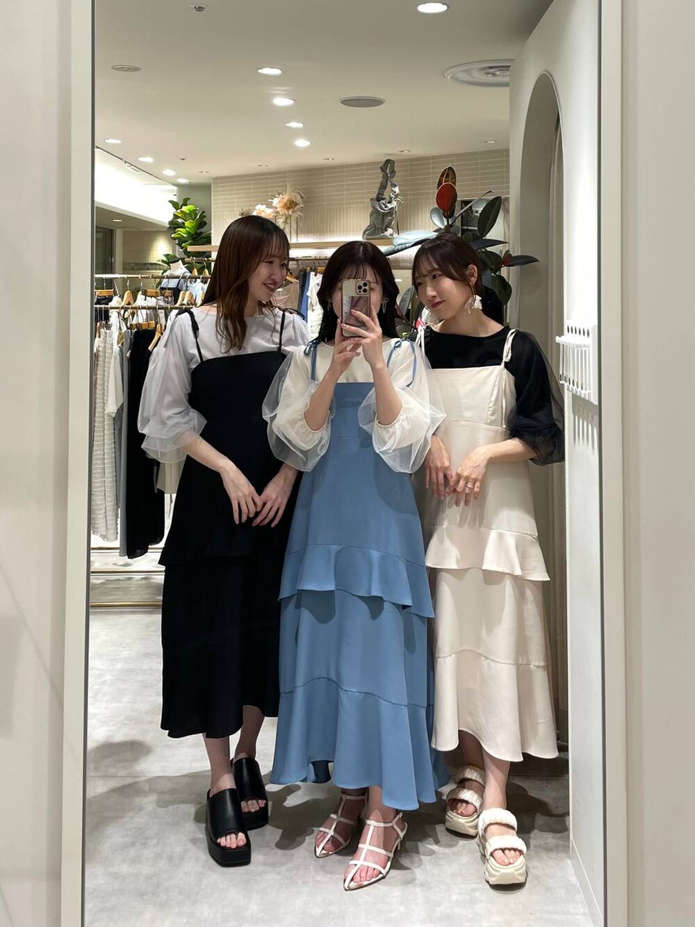 シルバー系のハンドバッグ、ホワイト系のサンダル、ブルー系のワンピースを着用したレディースの春コーディネートの5枚目の写真