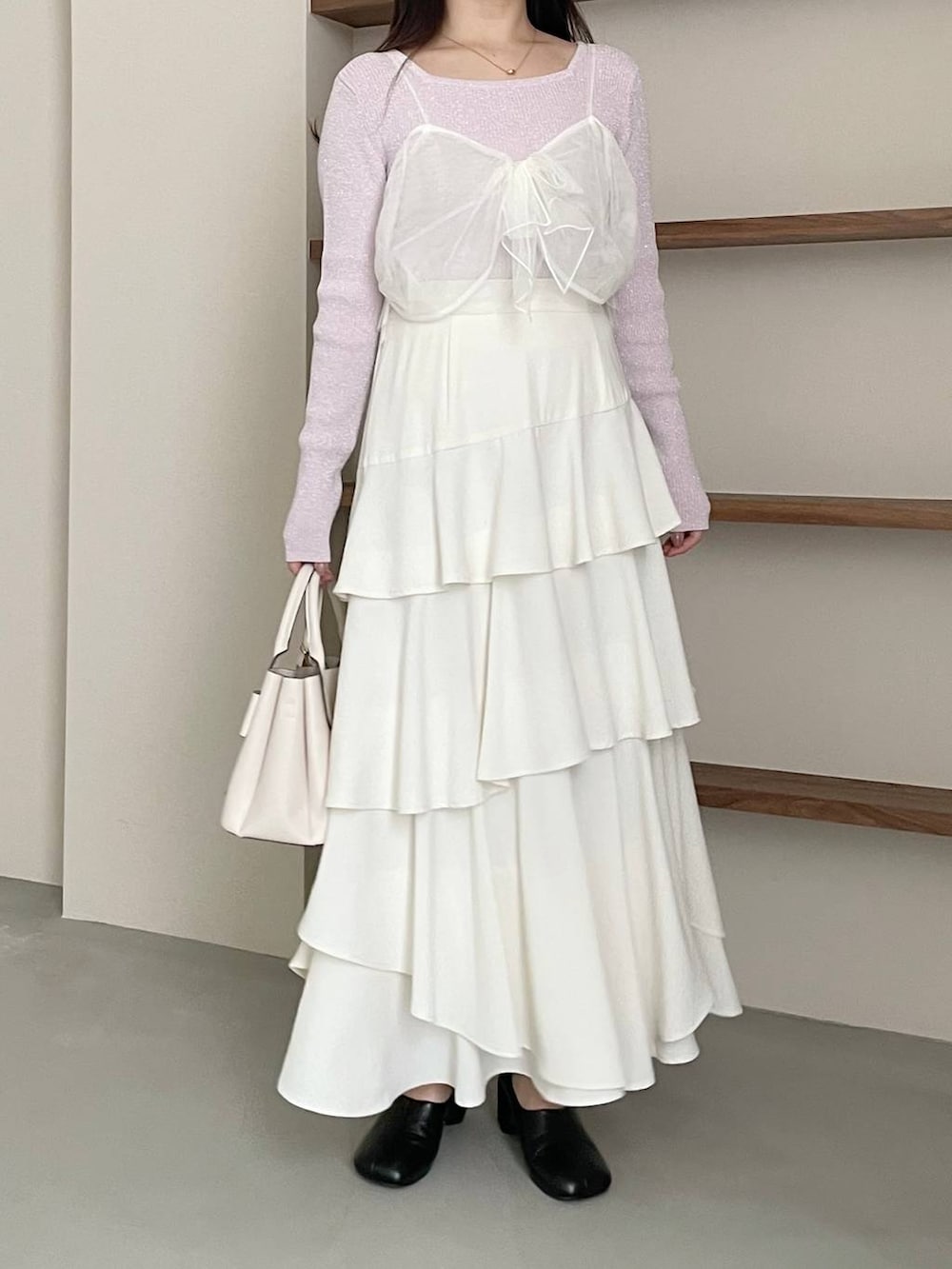 ホワイト系のスカート、ホワイト系のショルダーバッグ、ブラック系のパンプスを着用したレディースの冬コーディネートの6枚目の写真