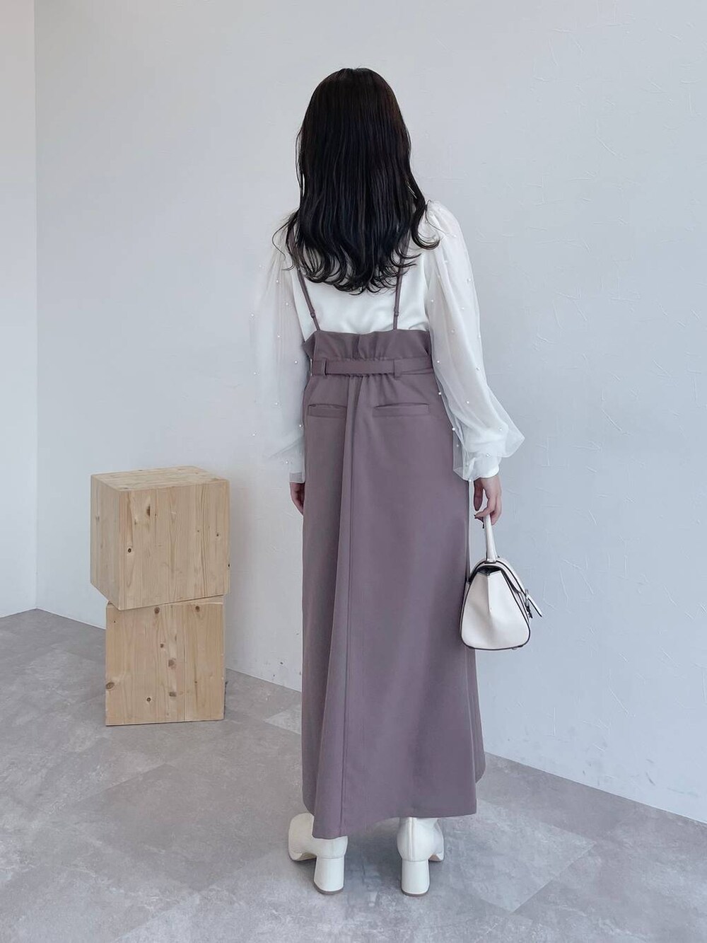 ブラウン系のチェスターコート、ホワイト系のハンドバッグ、ホワイト系のブーツを着用したレディースの夏コーディネートの6枚目の写真