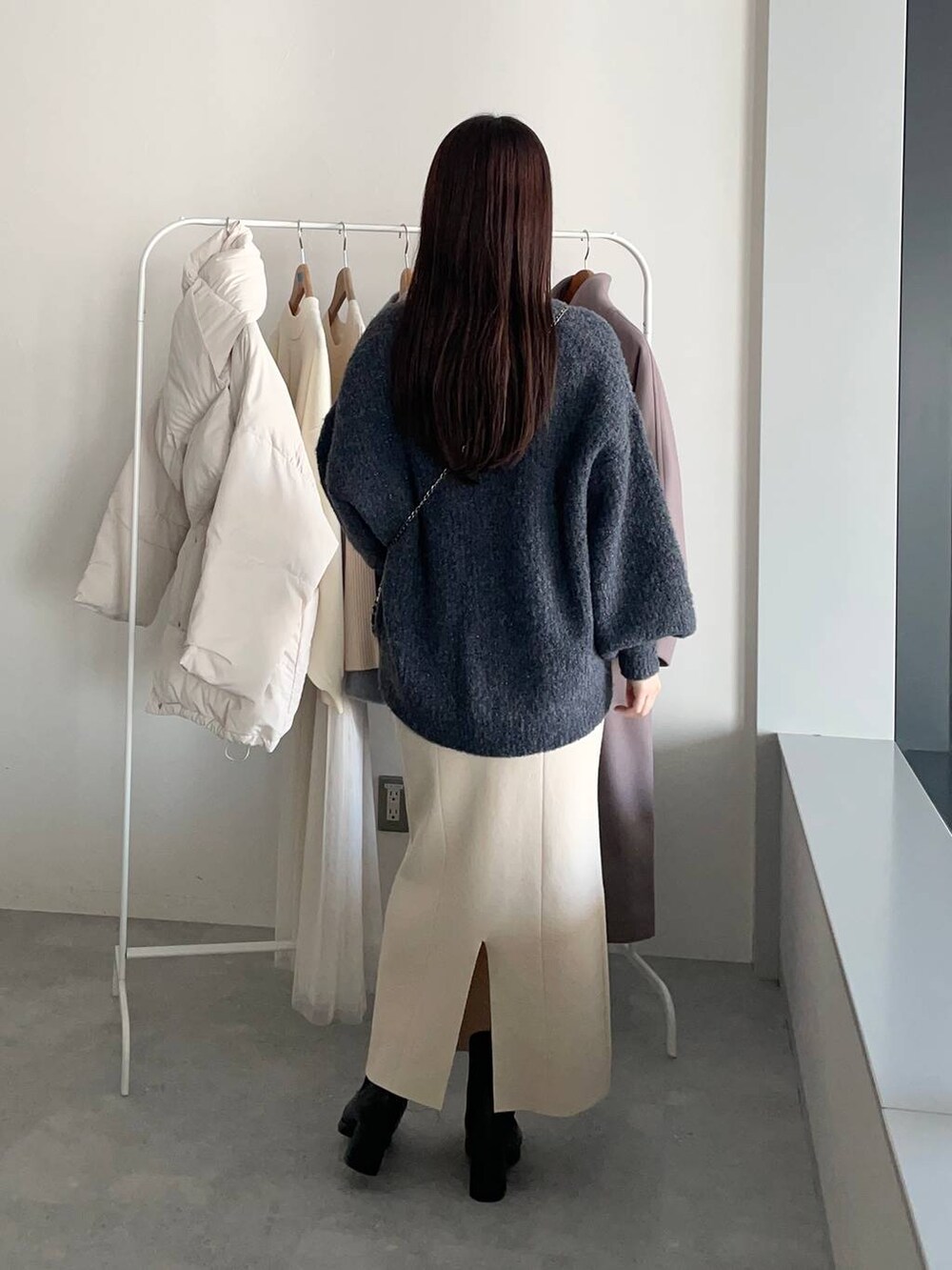 ブラック系のブーツ、ホワイト系のワンピース、グレー系のカーディガン/ボレロを着用したレディースの冬コーディネートの4枚目の写真