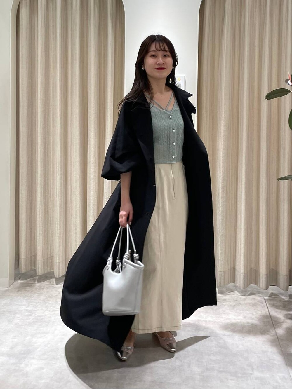 シルバー系のバレエシューズ、グリーン系のカーディガン/ボレロ、ホワイト系のスカートを着用したレディースの春コーディネートの4枚目の写真