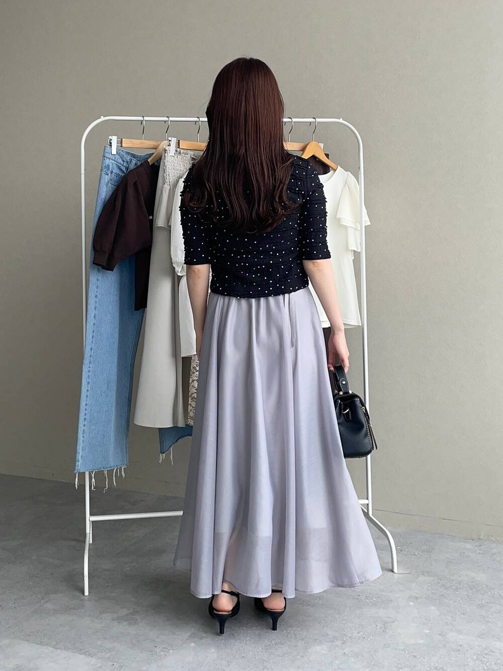 ブラック系のパンプス、ブラック系のショルダーバッグ、ブラック系のカーディガン/ボレロを着用したレディースの夏コーディネートの2枚目の写真