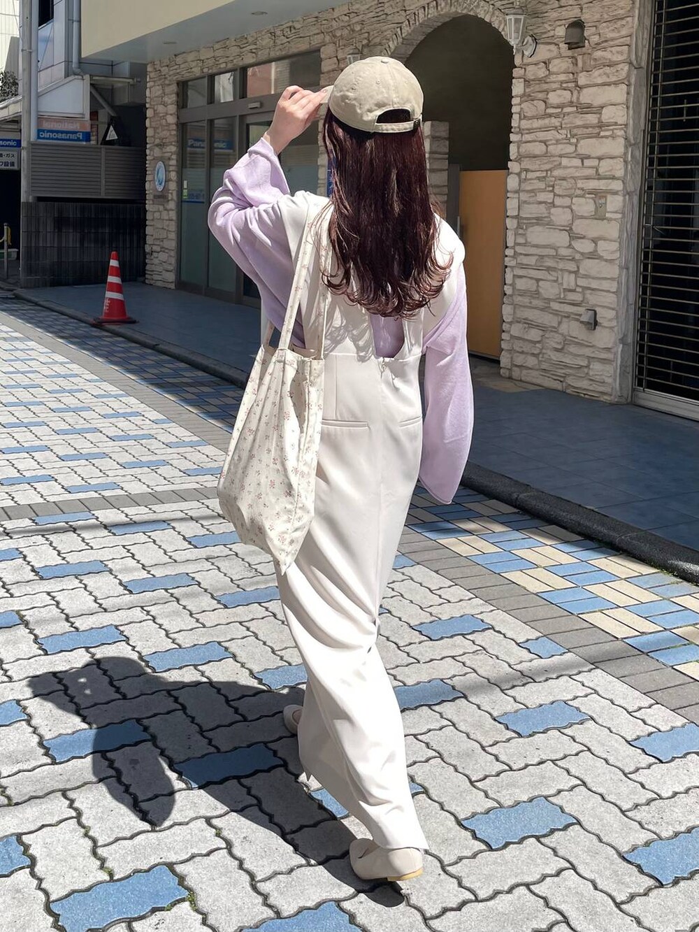 ベージュ系のパンプス、パープル系のニット/セーター、その他のトートバッグを着用したレディースの春コーディネートの2枚目の写真