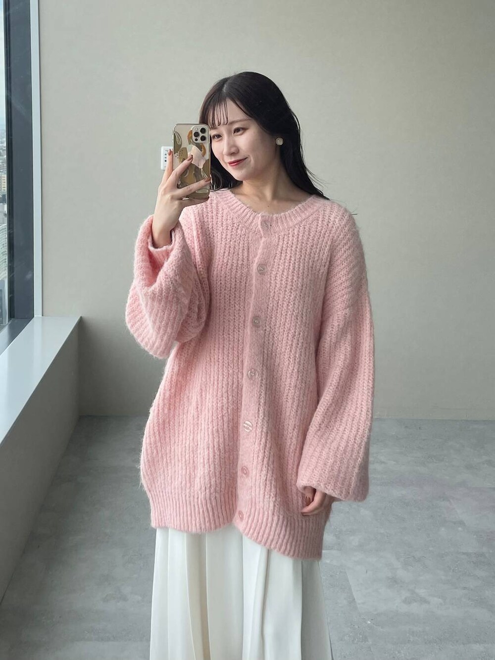 ブラウン系のブーツ、ピンク系のカーディガン/ボレロ、ブラウン系のハンドバッグを着用したレディースの秋コーディネートの5枚目の写真