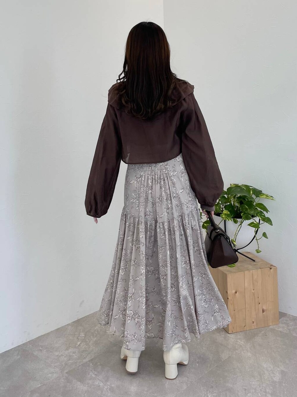 ブラウン系のハンドバッグ、ホワイト系のブーツ、ブラウン系のシャツ/ブラウスを着用したレディースの冬コーディネートの3枚目の写真