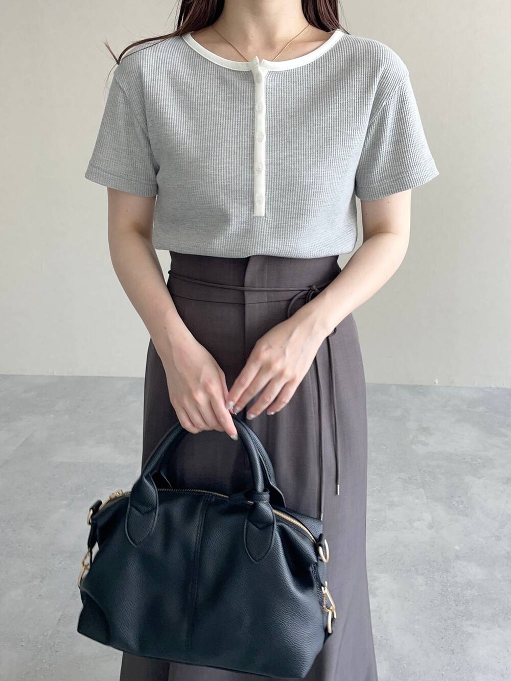 ブラウン系のテーラードジャケット、ブラック系のパンプス、ブラック系のボストンバッグを着用したレディースの春コーディネートの5枚目の写真