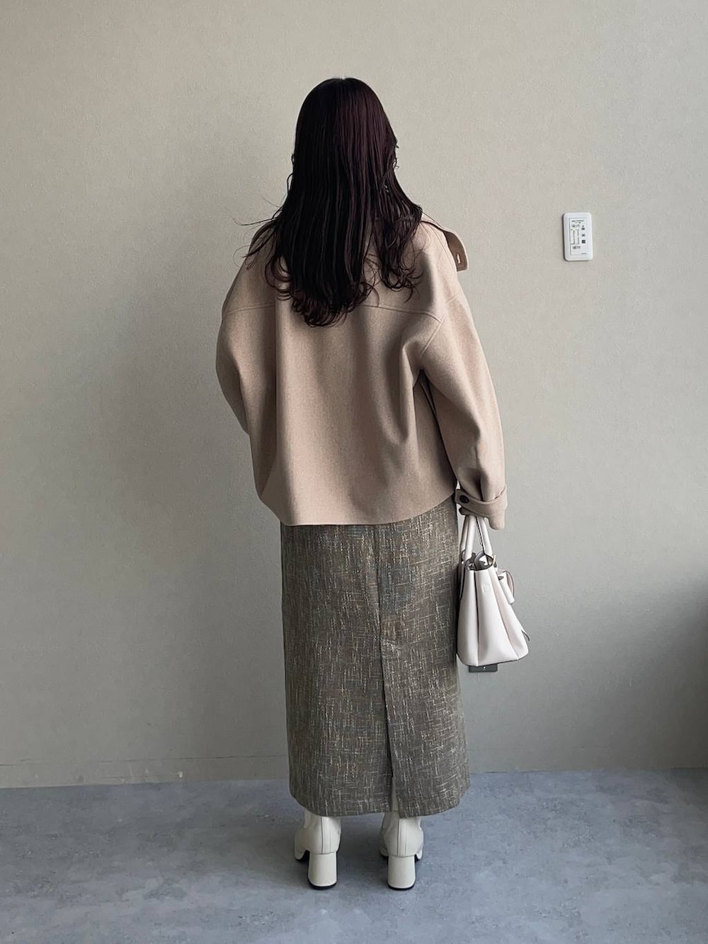 ホワイト系のピーコート、ホワイト系のブーツ、ホワイト系のニット/セーターを着用したレディースの秋コーディネートの2枚目の写真