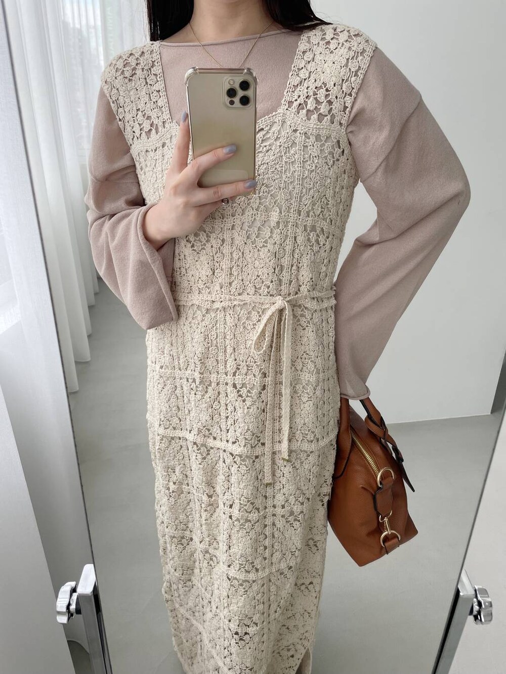 ベージュ系のニット/セーター、ホワイト系のワンピース、ブラウン系のボストンバッグを着用したレディースの春コーディネートの2枚目の写真