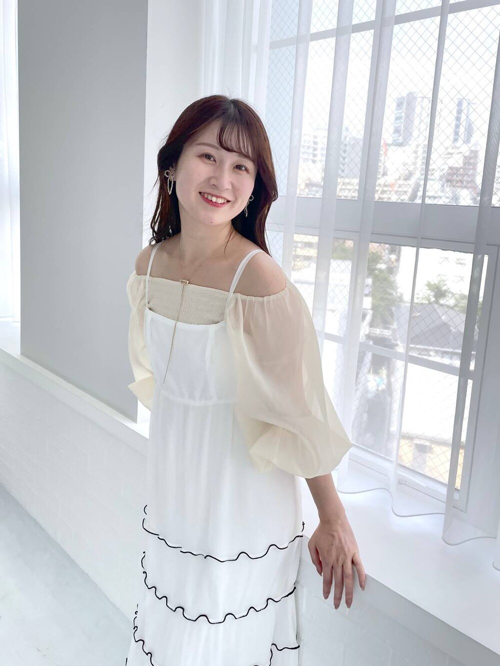 ブラウン系のショルダーバッグ、ホワイト系のサンダル、ベージュ系のTシャツ/カットソーを着用したレディースの夏コーディネートの3枚目の写真