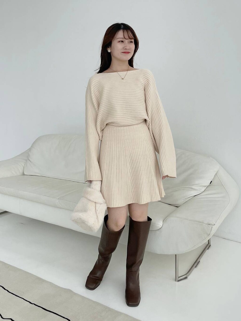 ブラウン系のブーツ、ホワイト系のハンドバッグ、ホワイト系のワンピースを着用したレディースの秋コーディネートの4枚目の写真