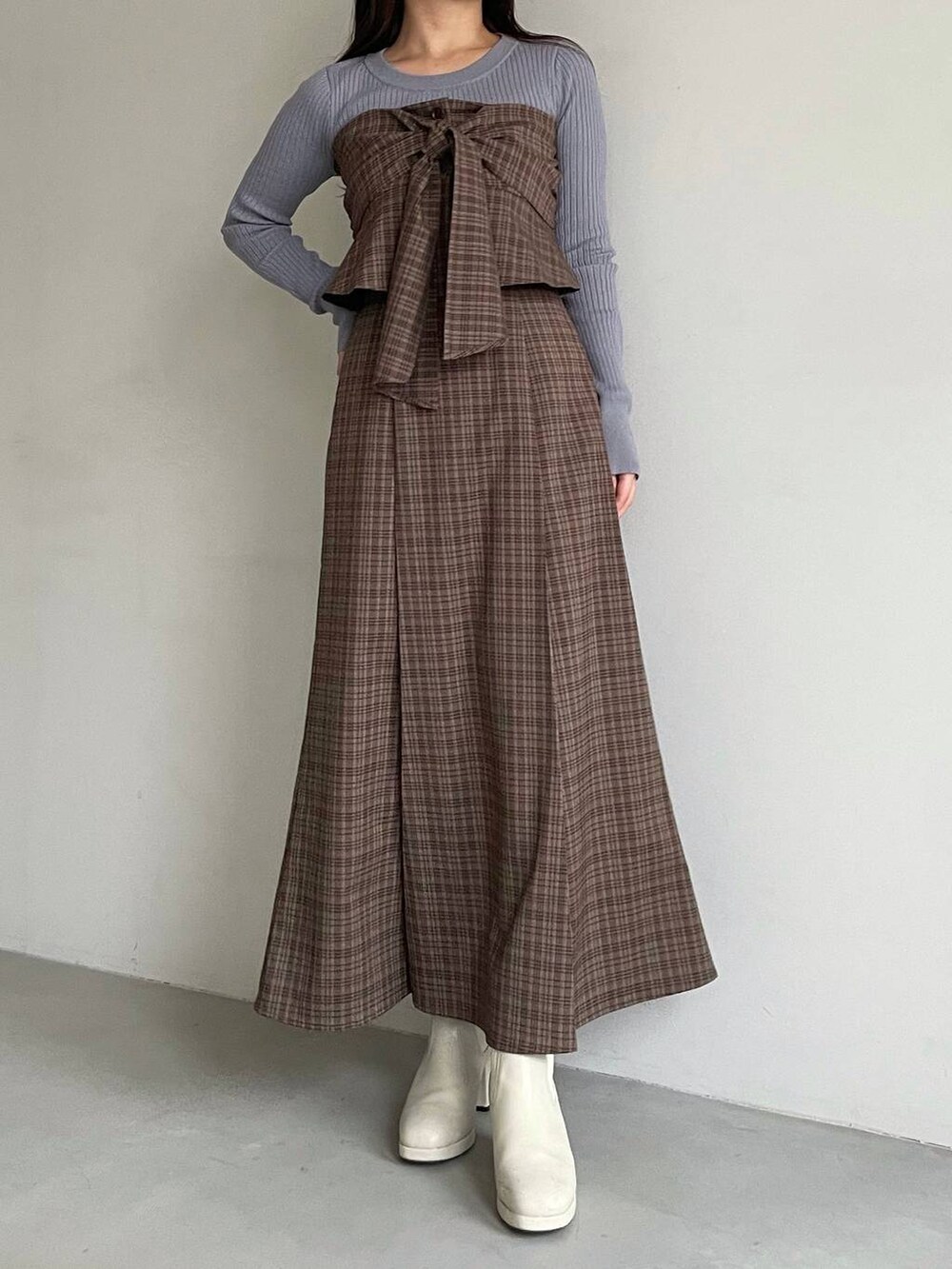 ホワイト系のブルゾン、ホワイト系のブーツ、ブラウン系のスカートを着用したレディースの冬コーディネートの6枚目の写真