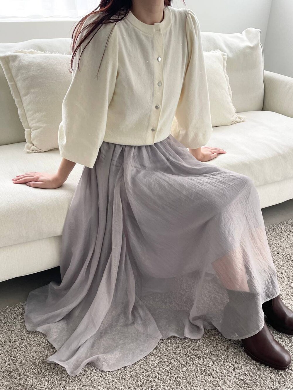 ブラウン系のブーツ、ホワイト系のカーディガン/ボレロ、ブラウン系のハンドバッグを着用したレディースの秋コーディネートの3枚目の写真