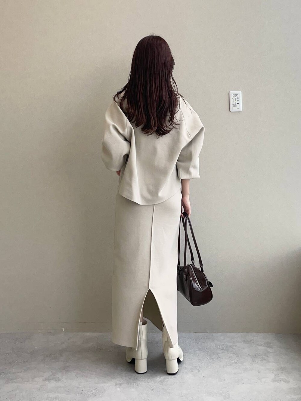 ホワイト系のブーツ、ホワイト系のニット/セーター、ホワイト系のスカートを着用したレディースの秋コーディネートの5枚目の写真