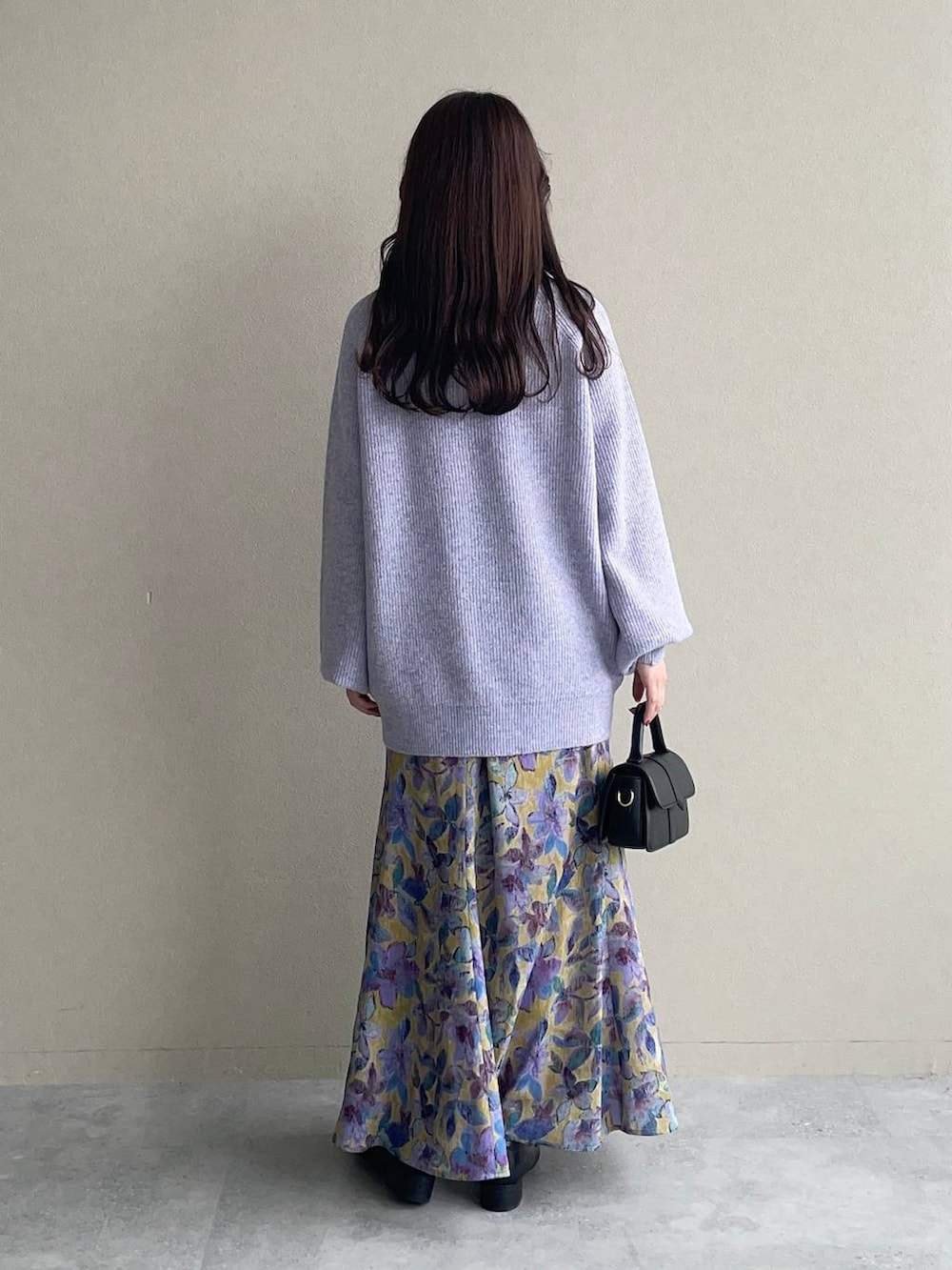 イエロー系のスカート、ベージュ系のマウンテンパーカー、パープル系のニット/セーターを着用したレディースの秋コーディネートの4枚目の写真