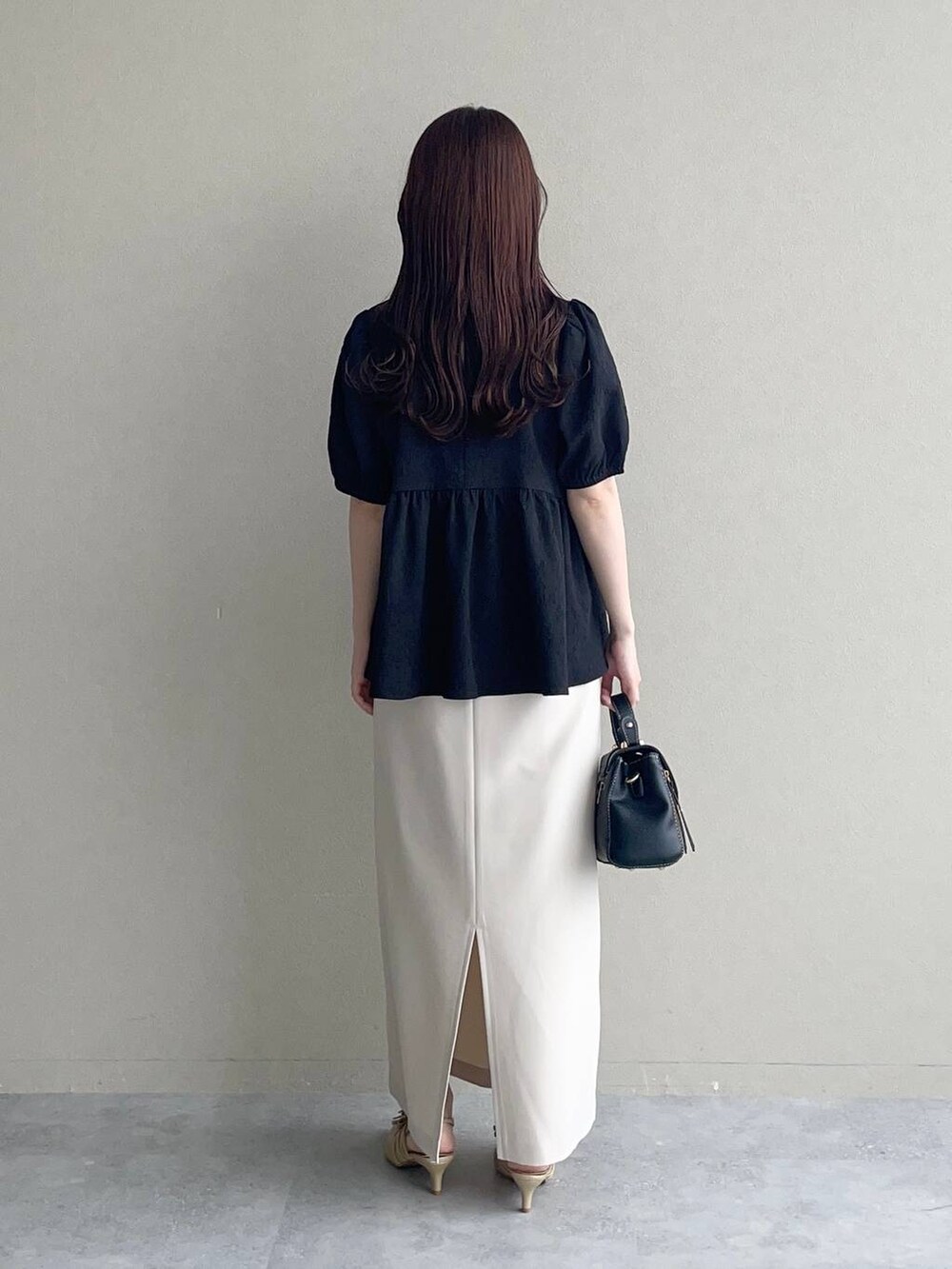 ゴールド系のパンプス、ブラック系のショルダーバッグ、ブラック系のシャツ/ブラウスを着用したレディースの夏コーディネートの2枚目の写真