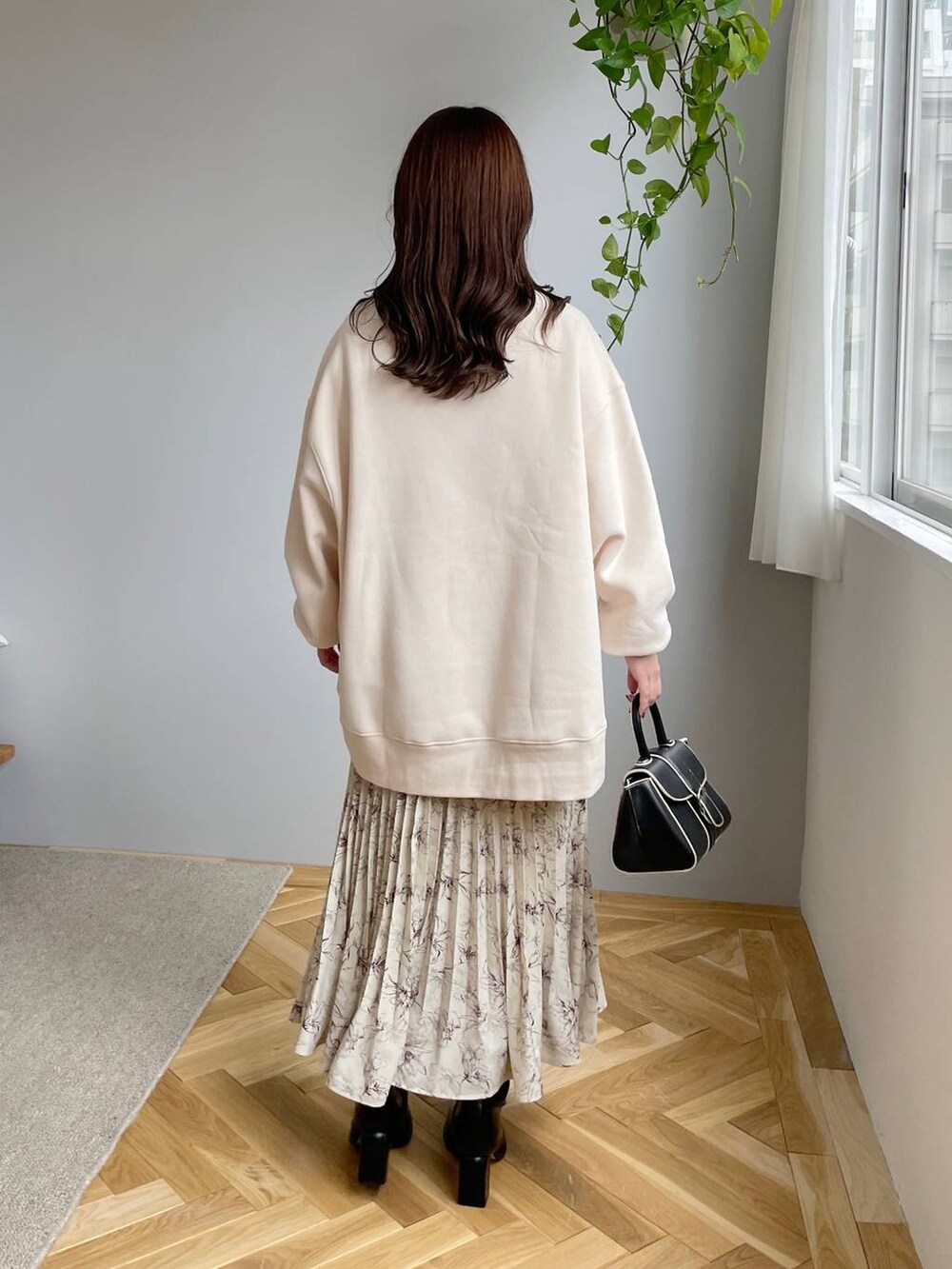 ブラック系のブーツ、ベージュ系のスカート、ホワイト系のスウェットを着用したレディースの秋コーディネートの2枚目の写真