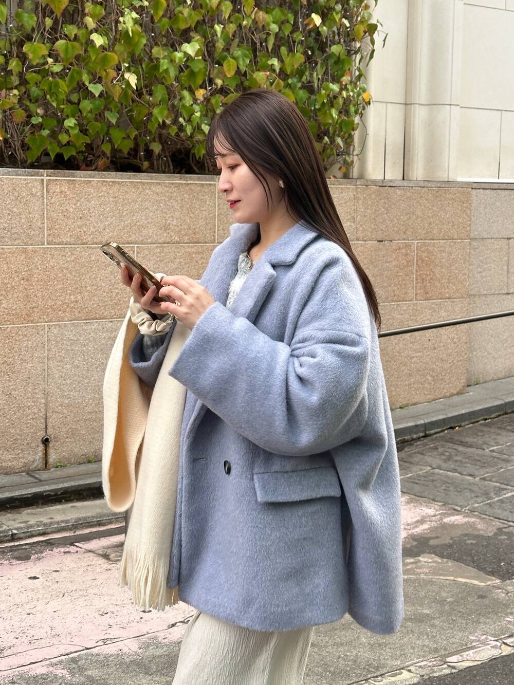 ホワイト系のスカート、グレー系のテーラードジャケット、ホワイト系のマフラーを着用したレディースの冬コーディネートの3枚目の写真