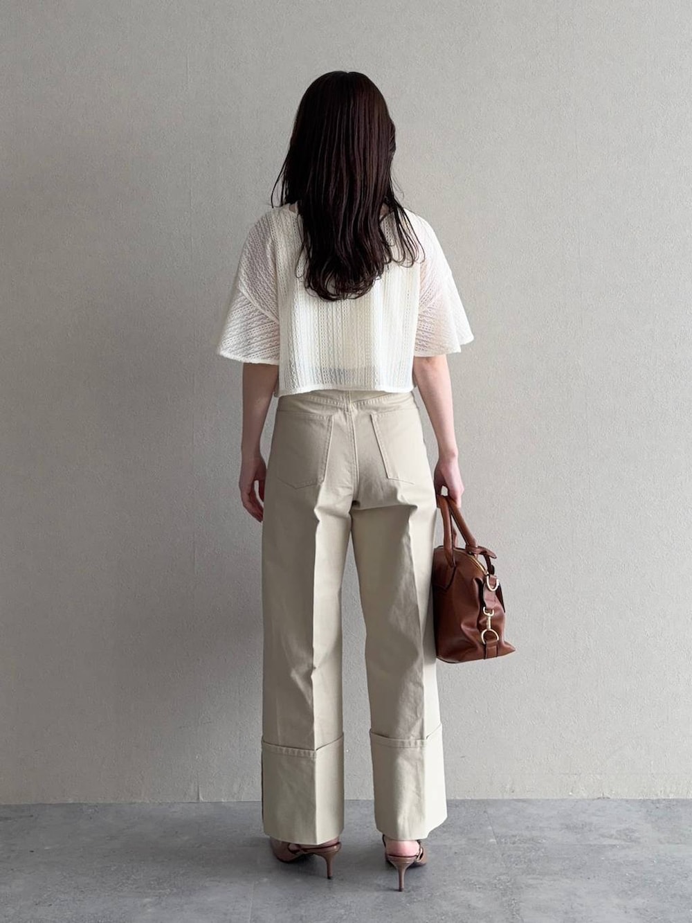 ホワイト系のカーディガン/ボレロ、ブラウン系のボストンバッグ、ブラウン系のサンダルを着用したレディースの春コーディネートの2枚目の写真